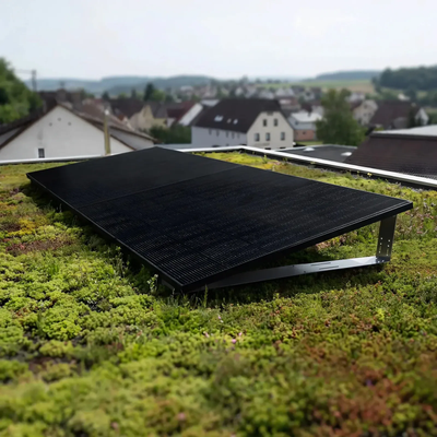 Aufgeständertes Solarmodul des Balkonkraftwerks auf einem begrünten Flachdach